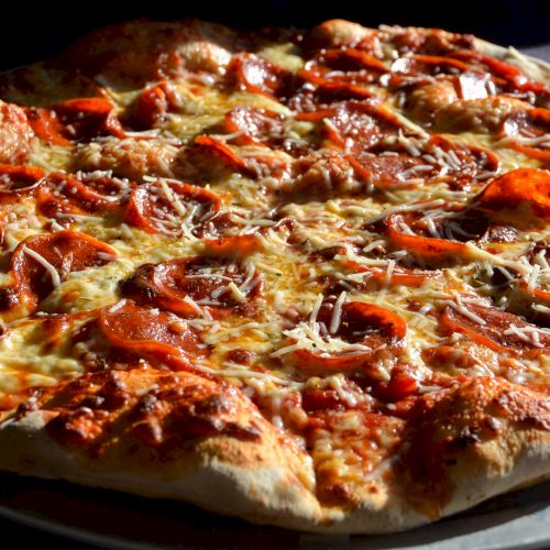 A pepperoni pizza with a golden-brown crust, melted cheese, and slices of pepperoni on top.